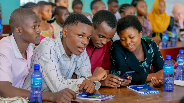 Élèves d’un Club d’intégrité consultant un téléphone pendant une formation de moniteurs (photo CERC)